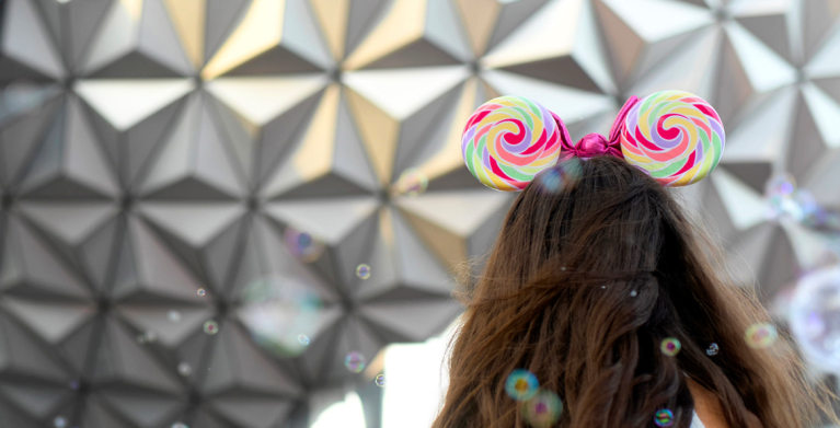 girl in mickey mouse ears looking at epcot sphere at walt disney world
