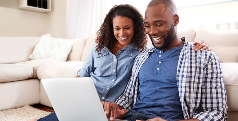 Couple protected by AAA Insurance on their computer reviewing their policy.