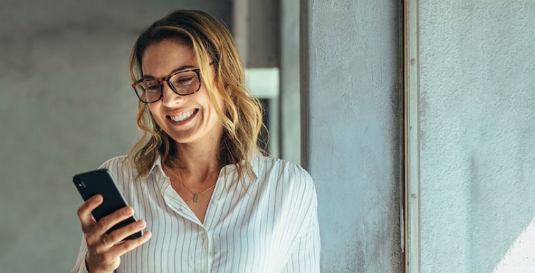 a woman compares AAA Membership costs and benefits on her mobile phone