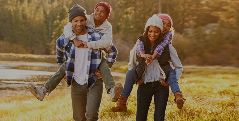 a family with AAA takes a fall hike near a lake