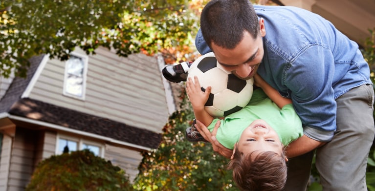 Father protected by AAA life insurance playing with his young son.