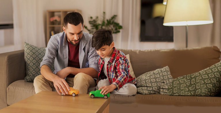 a father with aaa car and home insurance plays cars with his son