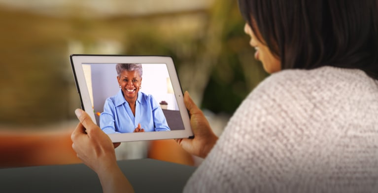Woman protected by AAA Insurance video chatting with her monther on an iPad