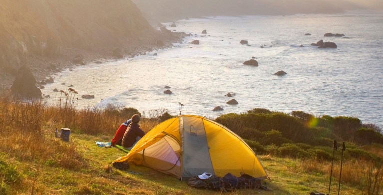 A couple camp on the bluffs above the Pacific Ocean.