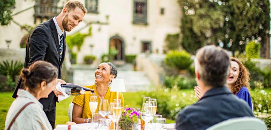 waiter serving meal to guests