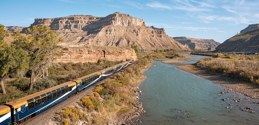 train next to river in desert