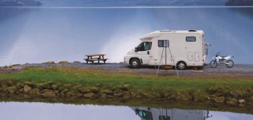 AAA Premier Members in their white RV by a lake
