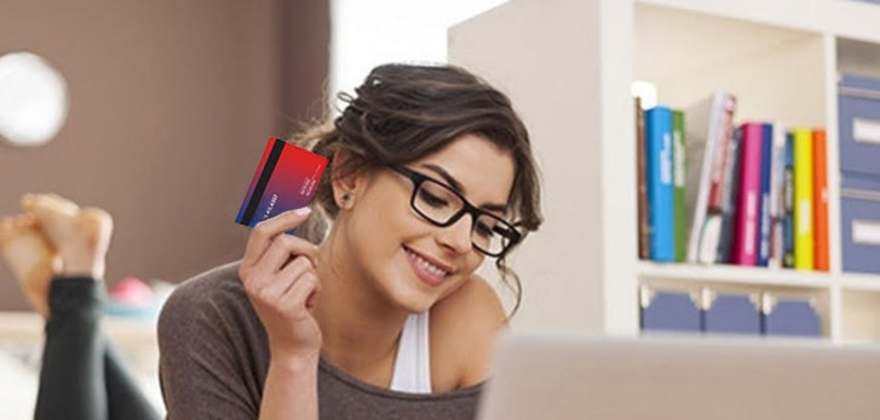 A woman uses her AAA discount while shopping online in her home office