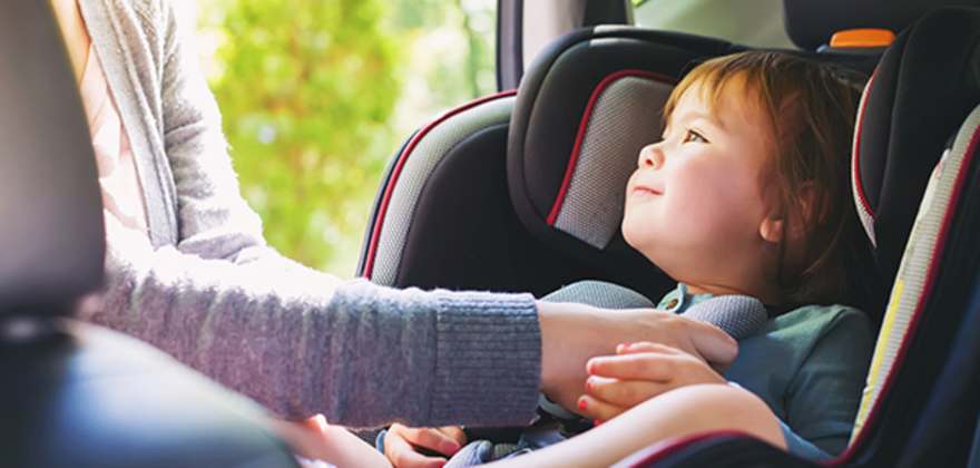A mother brings her child to AAA for a car seat inspection
