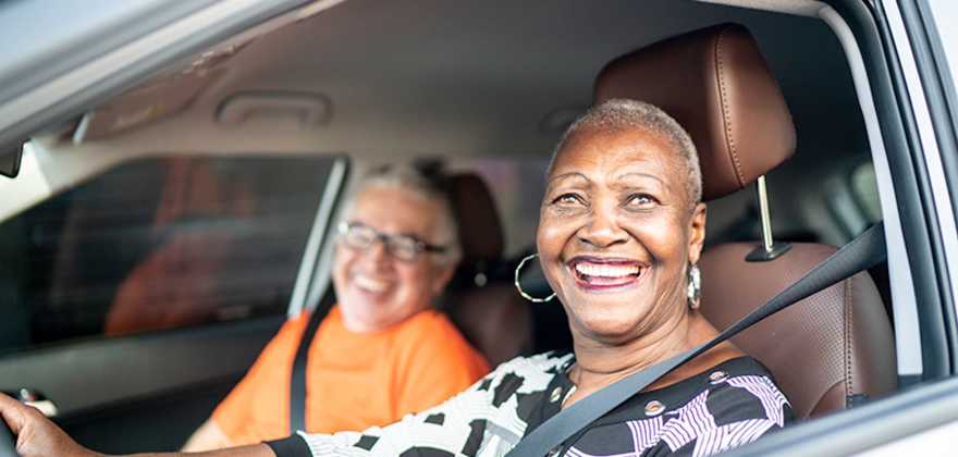 a retired AAA Member smiles from inside her car