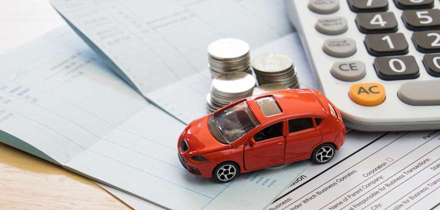 a toy car parked next to a calculator