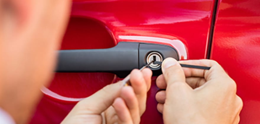a AAA locksmith unlocks a red car door