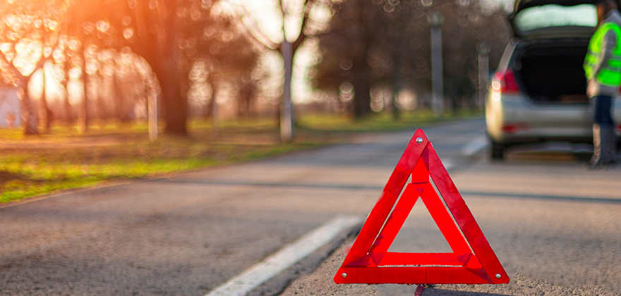 safety triangle in the street indicating stopped car on the road ahead
