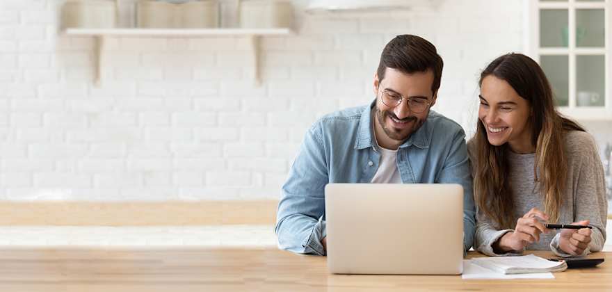 a couple learns about insurance premiums vs. insurance deductibles on their laptop