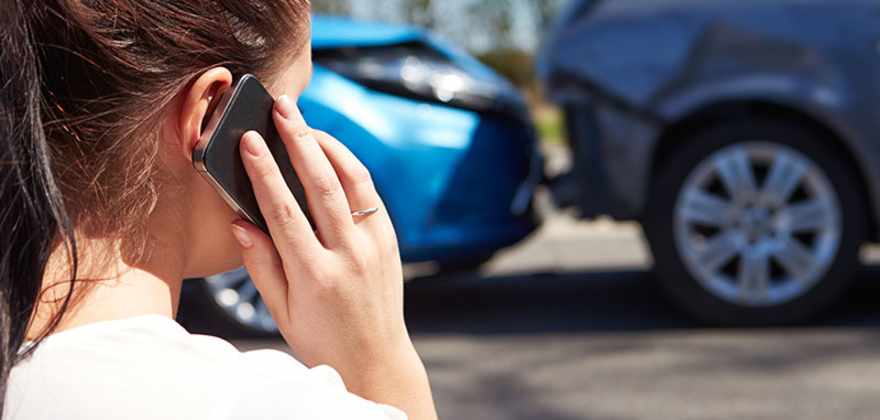 woman on her cellphone after a car accident
