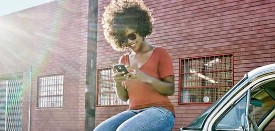 A Member sits on their car and uses their roadside Membership