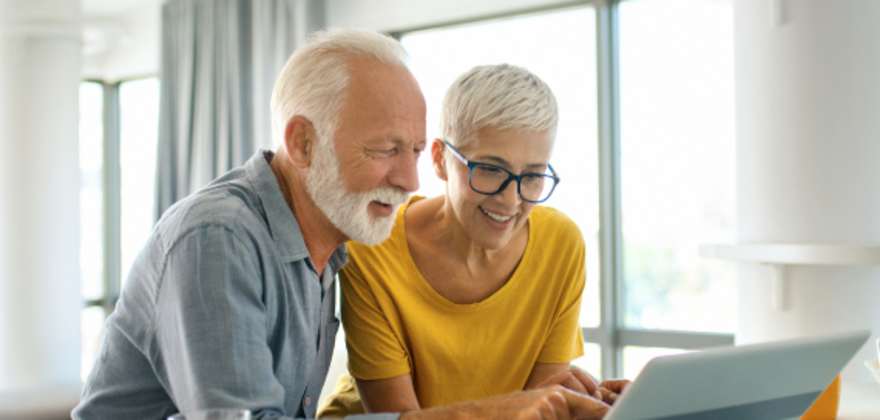 A couple looks at a laptop
