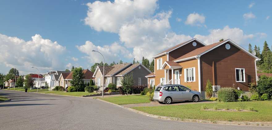 A car in the driveway and home protected by AAA Insurance