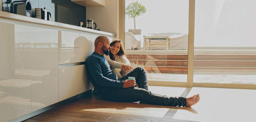 a couple stands in front of their new home  with AAA homeowners and earthquake insurance 