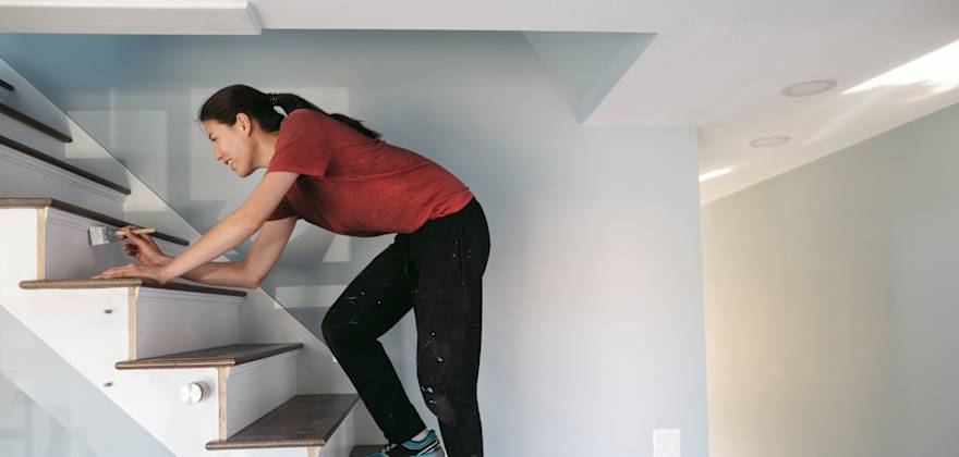 woman painting interior steps.