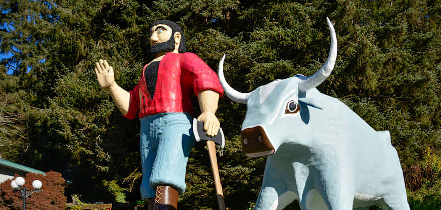 Paul Bunyan waves and leans on his ax beside Babe the Blue Ox, in Klamath, California