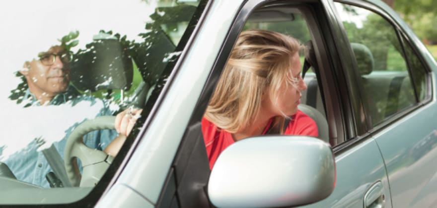 Woman driving and checking blind spot for traffic