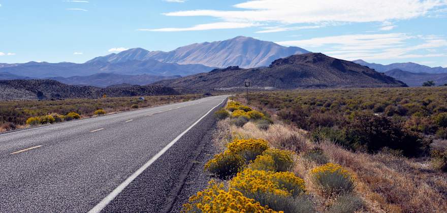 Empty Highway 50 stretches into the Nevada desert on a party cloudy day.