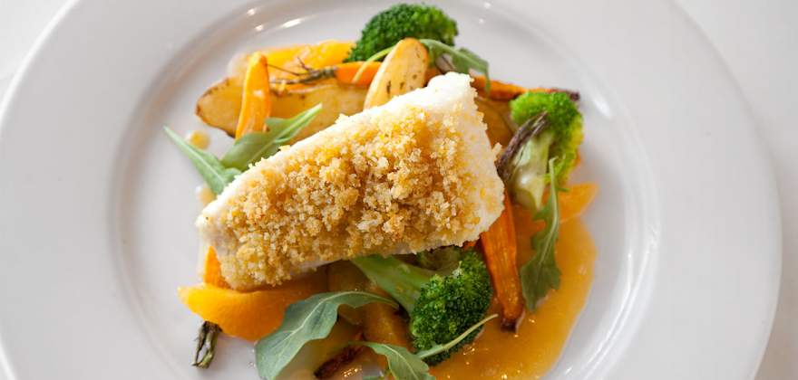  Citrus- and Almond-Crusted Halibut on a white plate.
