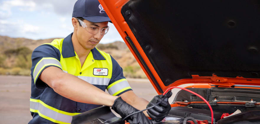 A technician jump-starts a vehicle