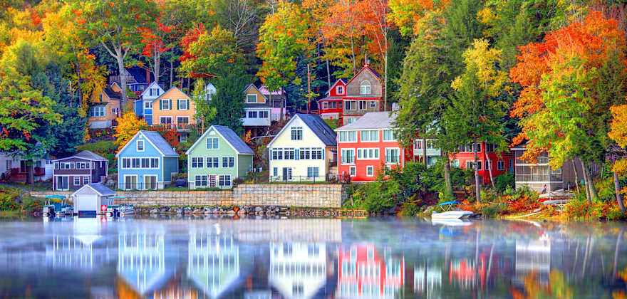 see fall foliage and houses on a lake in new england with member choice vacations