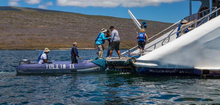 people boarding a boat from rubber raft