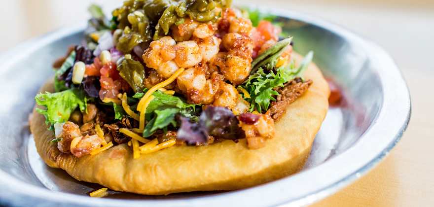 Loaded fry bread on a table at Tacobe in Denver, Colorado.