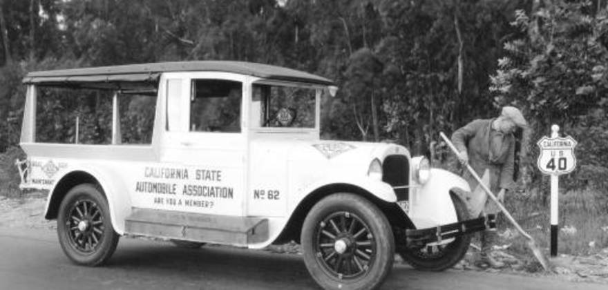 Old AAA truck with worker cleaning up along California highway 40