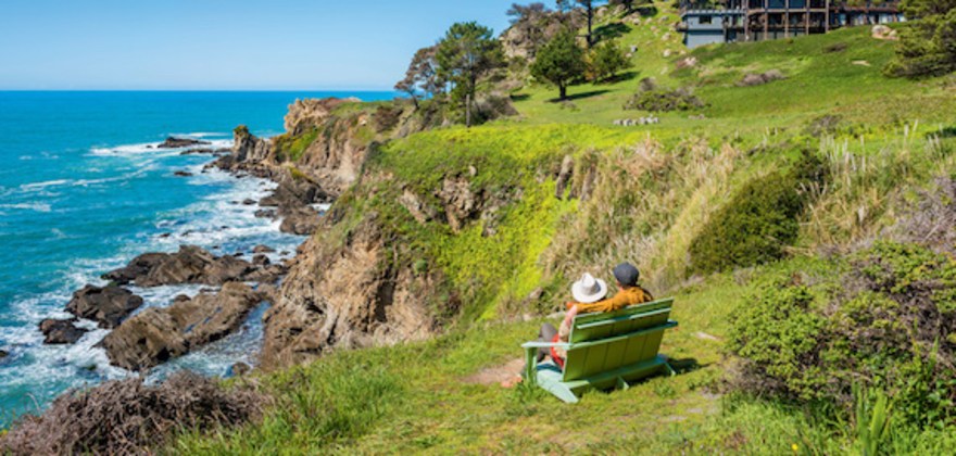AAA Members sitting on a bench on the coast