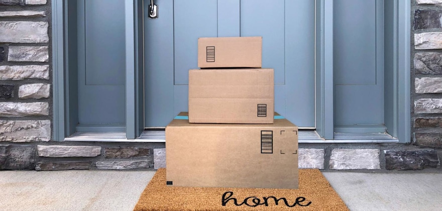 three packages stacked on mat at doorstep