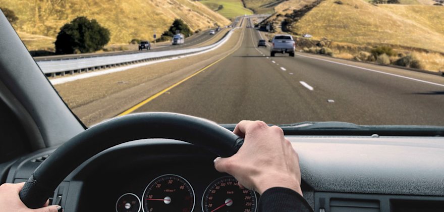 driver's point-of-view, onto highway passing lane, with both hands on wheel