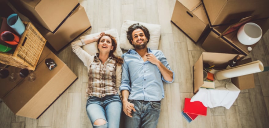 a couple with aaa membership rests on the floor of their new home after moving with aaa discounts