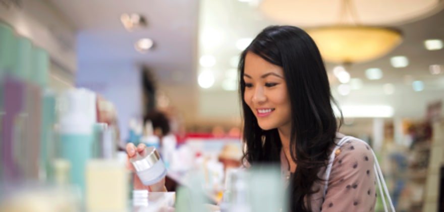 a female aaa member shops at the perfume counter with her aaa member discount
