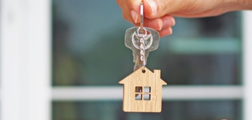 a landlord with AAA rental property insurance hands over keys to an apartment