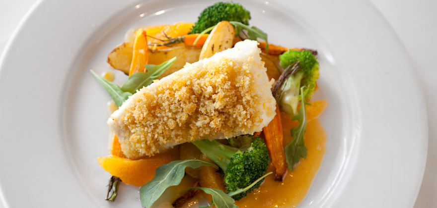  Citrus- and Almond-Crusted Halibut on a white plate.