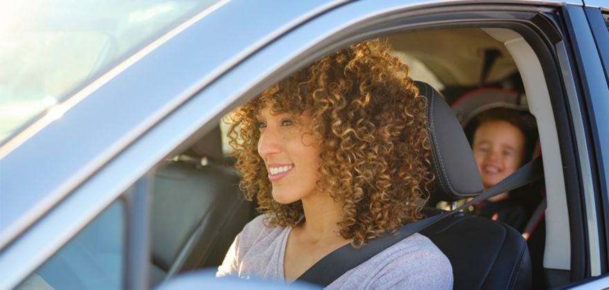 Woman driving with kid in backseat