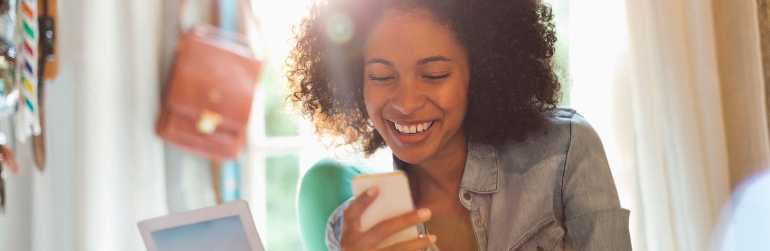A woman looking at her phone, smiling