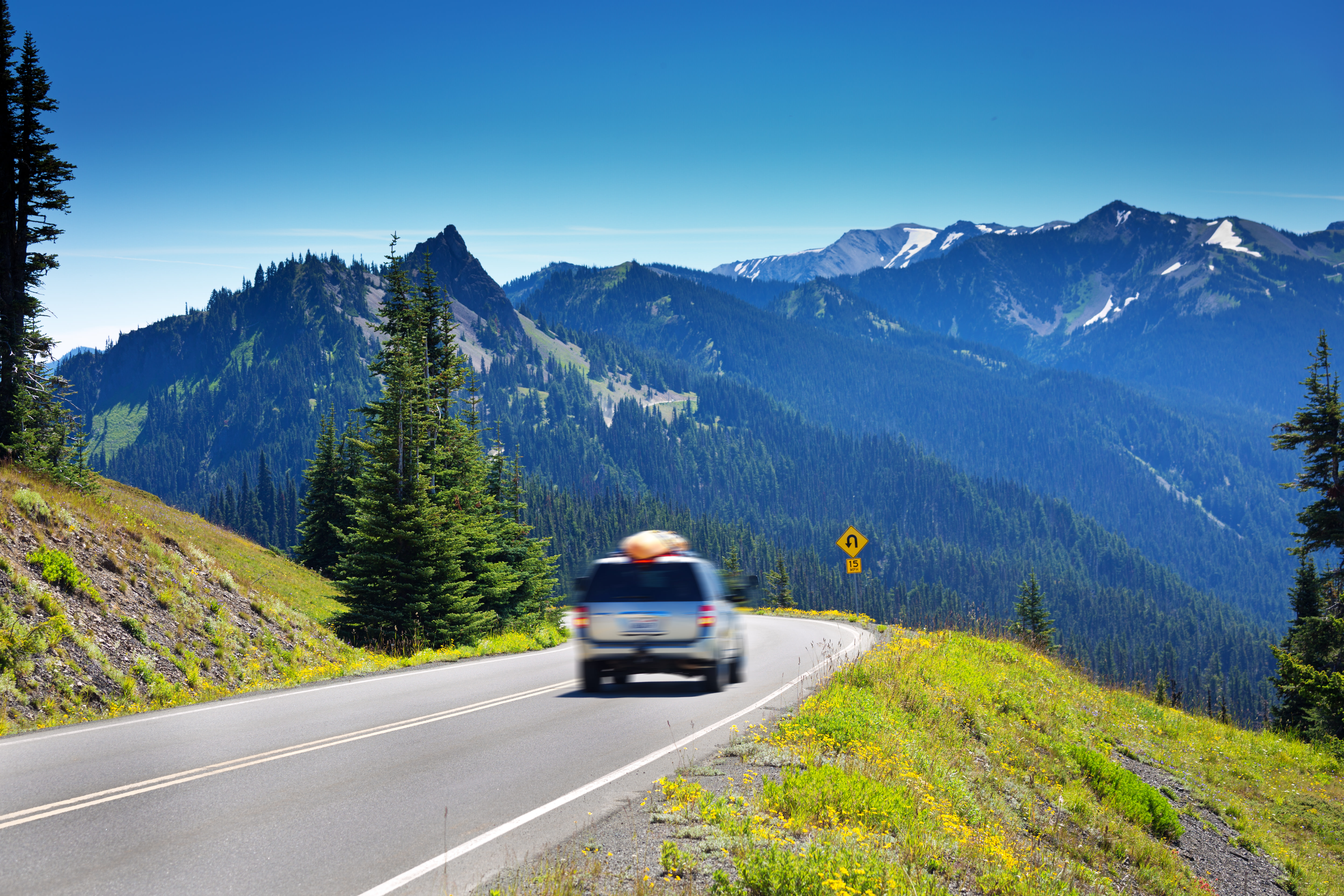 AAA Member walking away from her car on a mountain road.