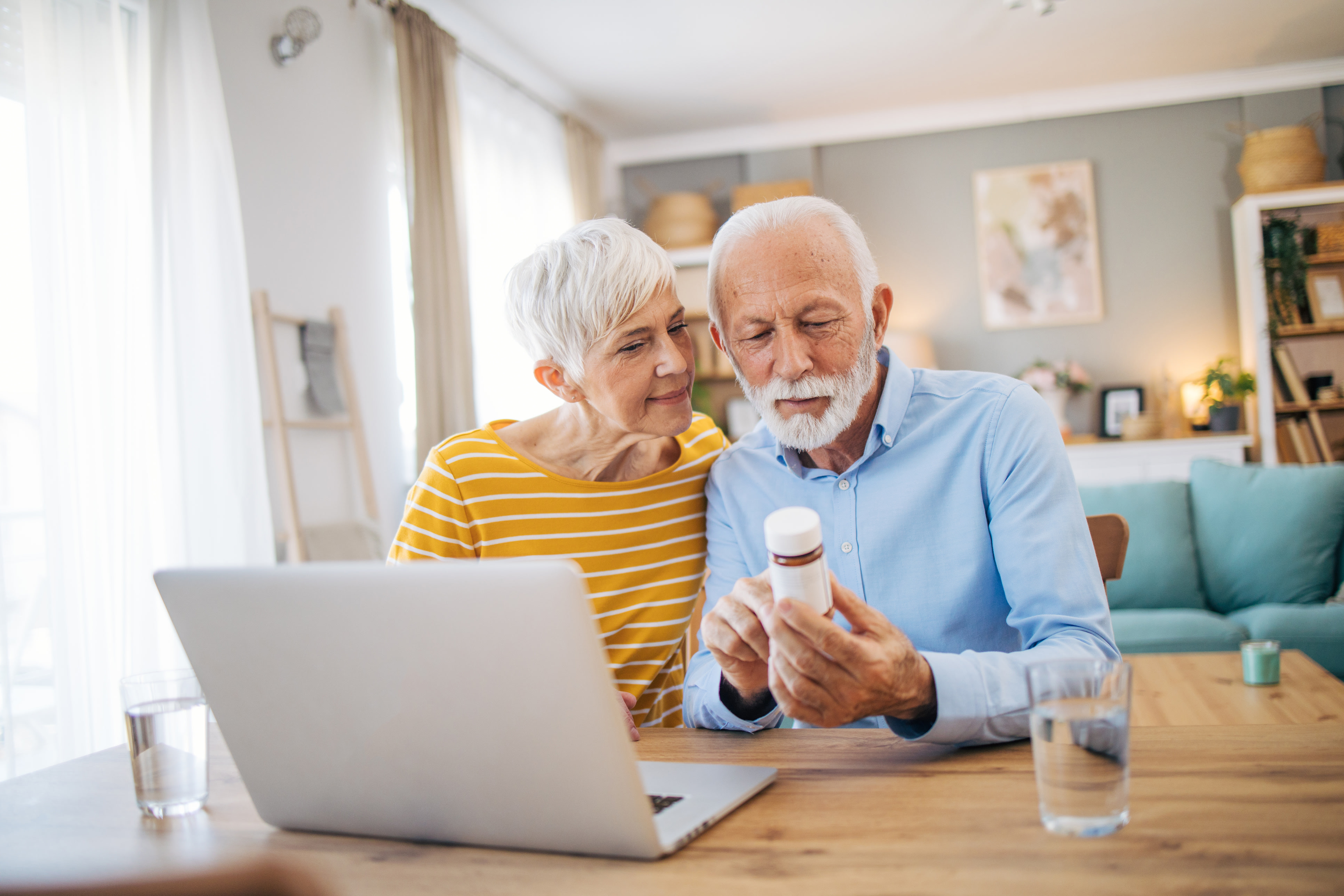 Elderly couple reading medicine bottle description 