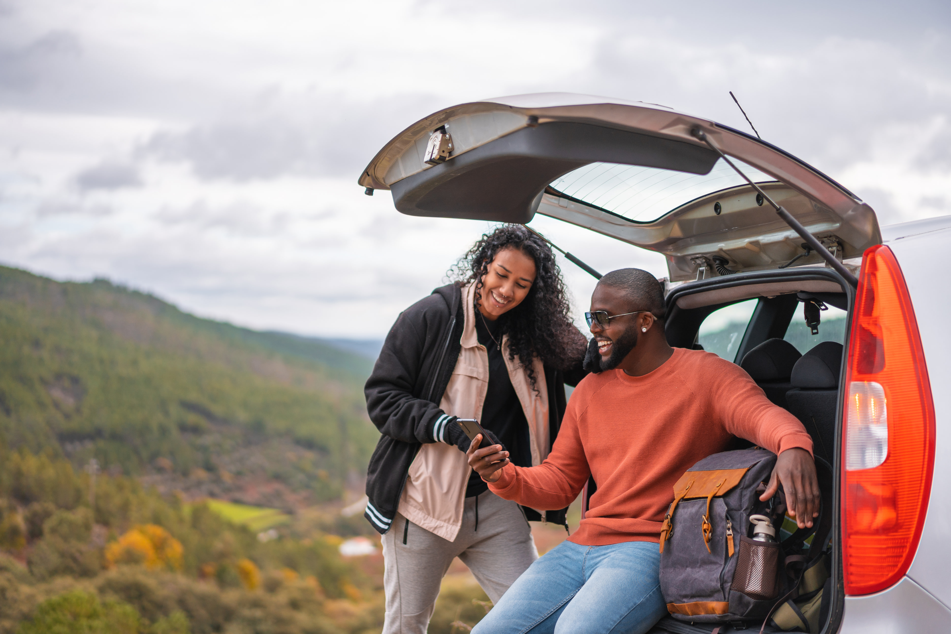 a family with AAA takes a fall hike near a lake