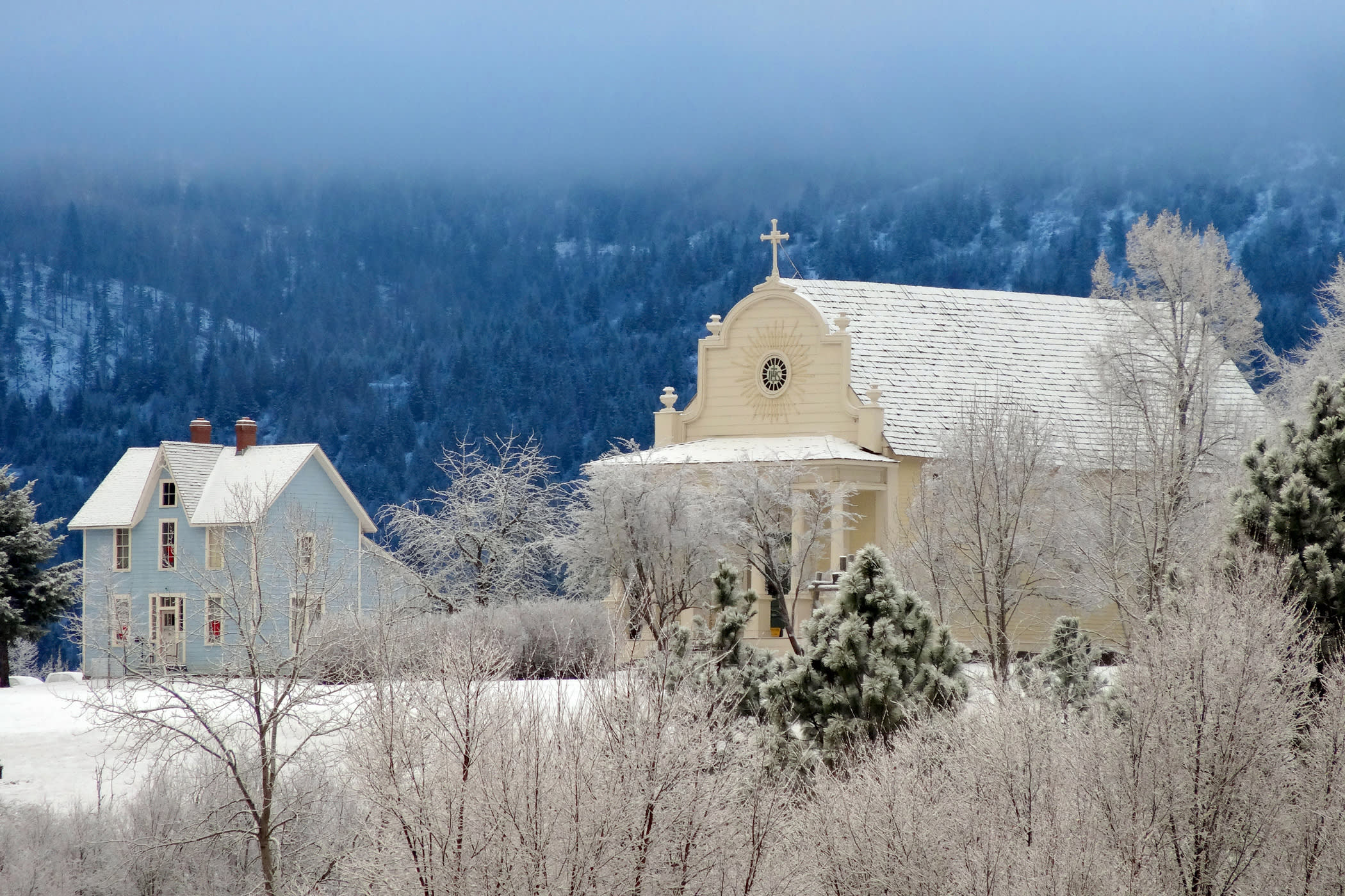 photo of an old house and church covered in snow at Old Mission State Park