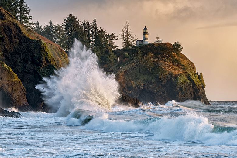 waves crash on the rocky shoreline at Cape Disappointment Lighthouse in Washington, picture