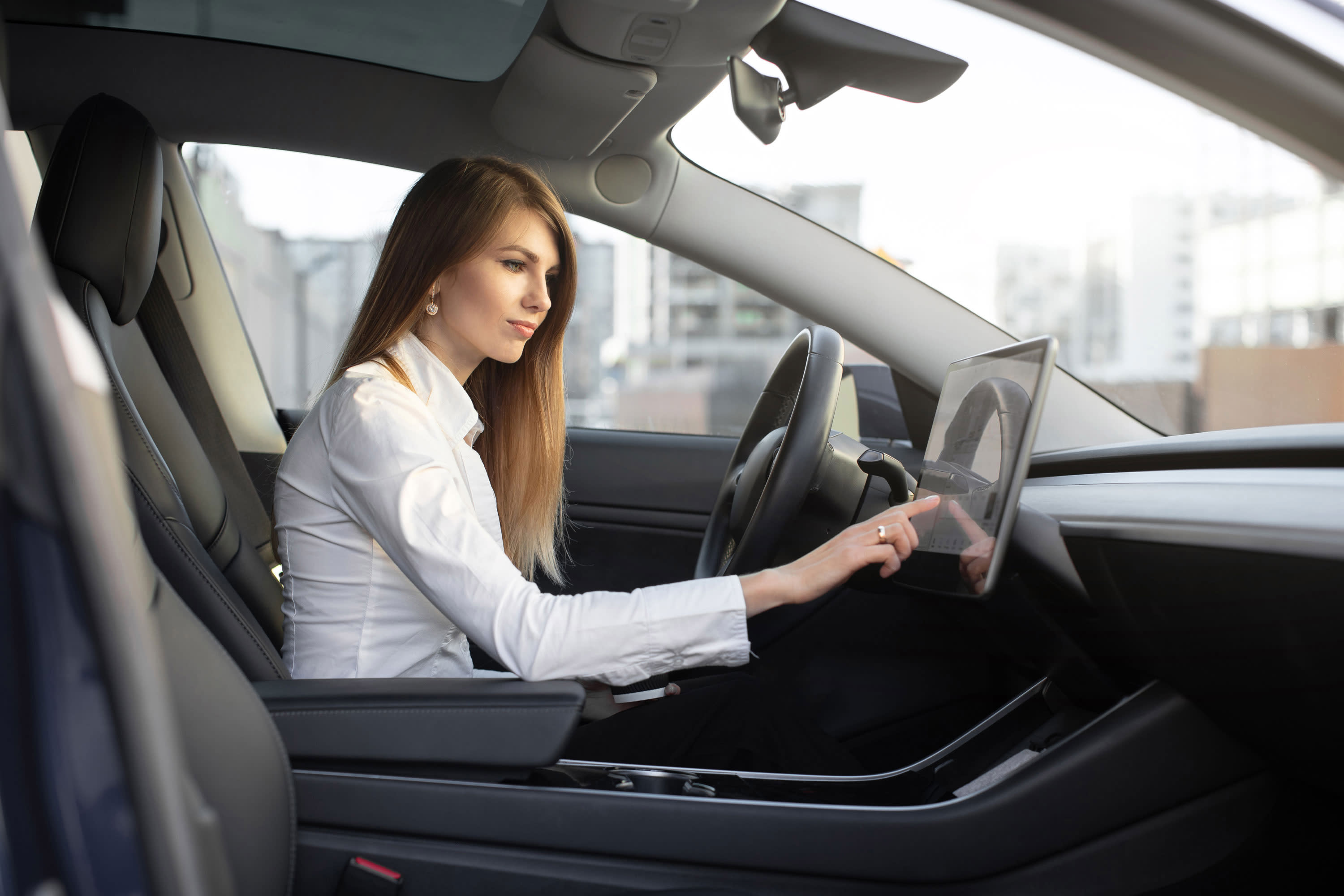 A woman uses the navigation system in a rented Tesla.