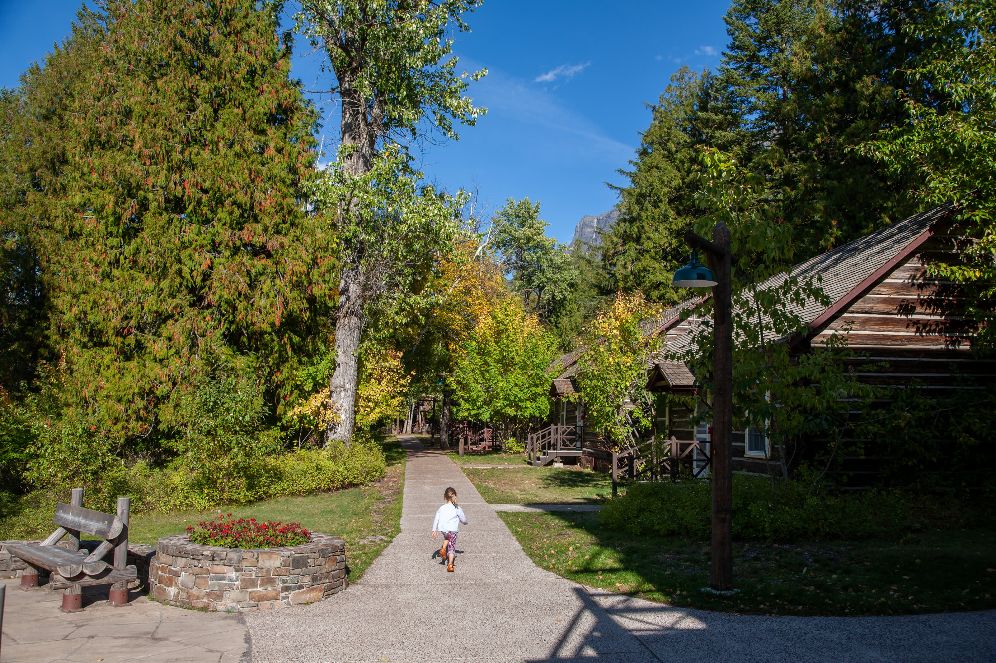 A young girl runs down the path for the Lake McDonald Lodge cabins.