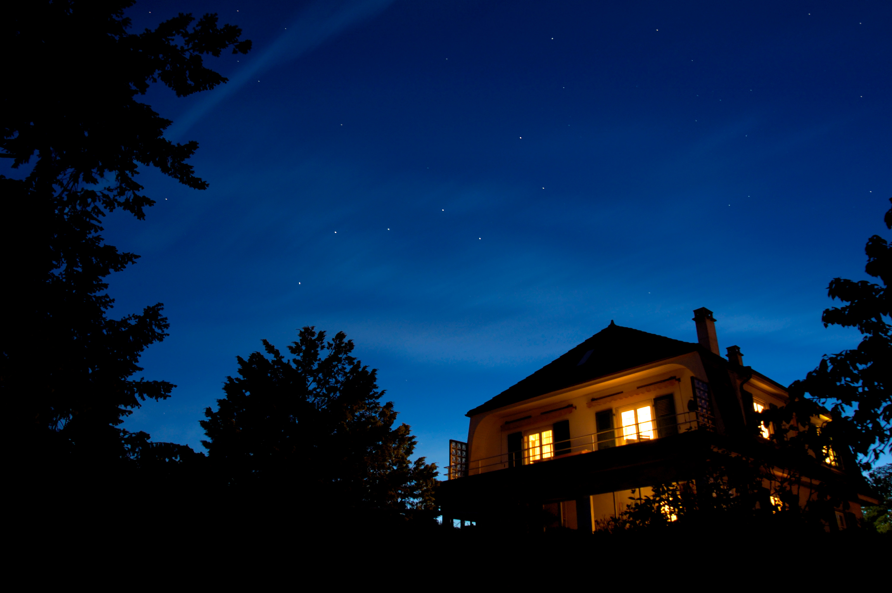 Stars come out over a home lit up at night.